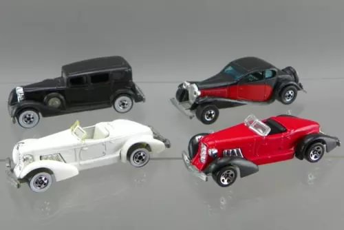 1/64 diecast car lot with four vintage-style vehicles: black, red, white, gray-blue