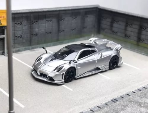 Silver diecast racing sports car model with black wheels, angled in display