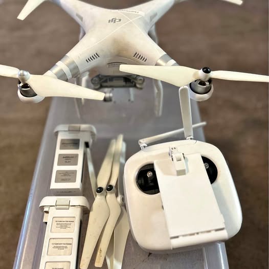 White quadcopter drone with front camera and four propellers