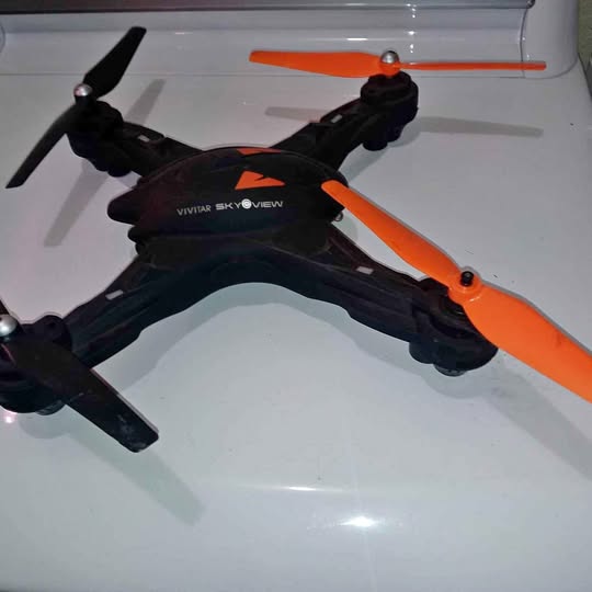 Black and orange quadcopter drone with four propellers
