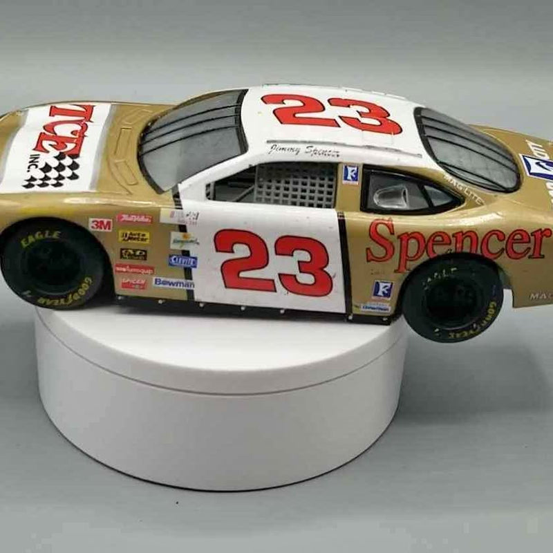White diecast NASCAR stock car with red number 23 and Spencer logo, front 3/4