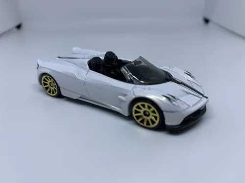 White and black die-cast roadster model with gold wheels and black hood detail