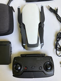 Arctic white camera drone with fold-out arms and black remote controller
