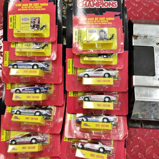 Diecast racing car set in red blister packs, multiple cars with yellow base cards