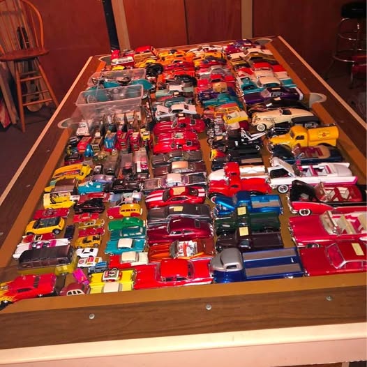 Diecast car collection: assorted colorful model cars in a wooden tray
