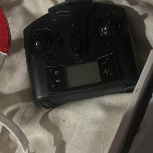 Black RC drone controller with built-in LCD screen and buttons