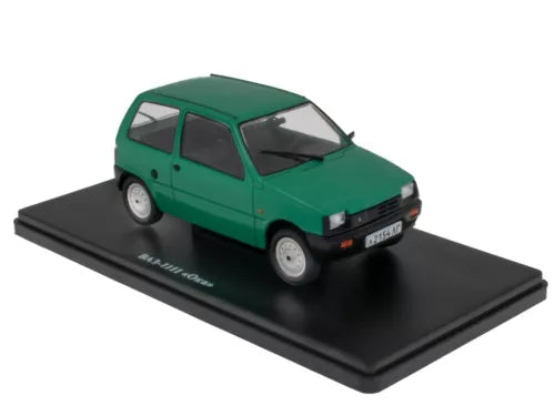 Green diecast miniature car model on black display base, front three-quarter view
