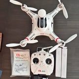 RC camera drone with white quadcopter, controller, batteries and user manual