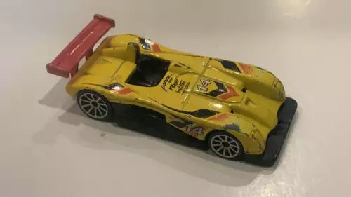 Yellow toy diecast sports car with open hood, racing decals, black wheels.
