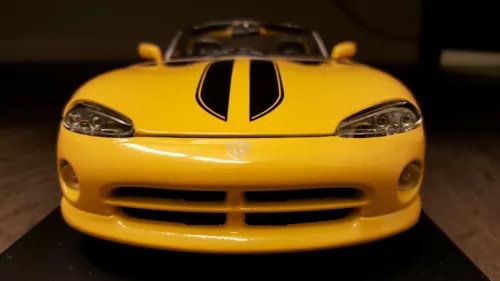 Yellow diecast sport car model, front grille and headlights visible