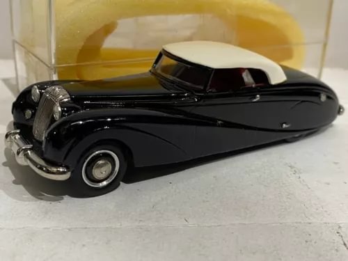 Black diecast model car with white roof, front three-quarter view.