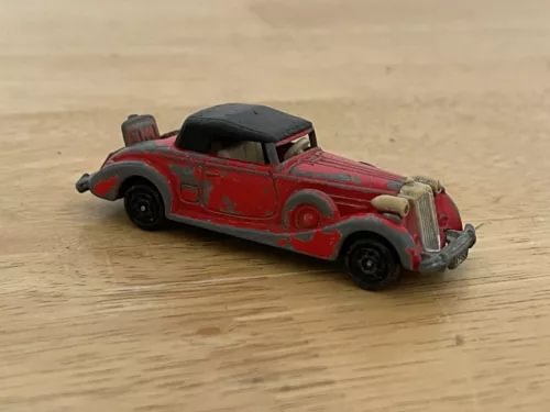 Red diecast roadster model car with black wheels and roof