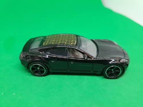 Dark green diecast model car, side view with black wheels and detailed roof