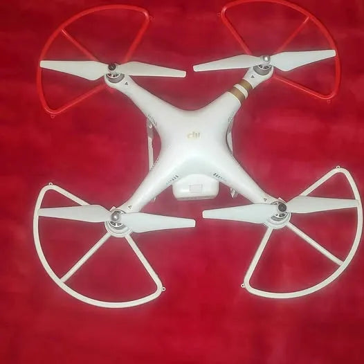 DJI Phantom 4 quadcopter drone with four propellers, white body.