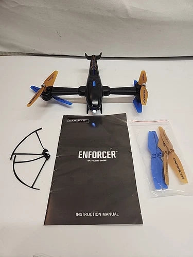 Folding drone with four propellers, instruction manual, and extra blades set.