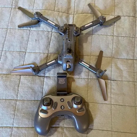Folded quadcopter drone with four propellers and handheld remote controller