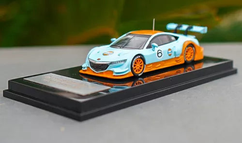 1/64 diecast race car model with light blue and orange body, front 3/4 view