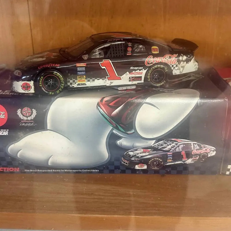 Diecast race car in packaging, black with red number 1 and sponsor decals