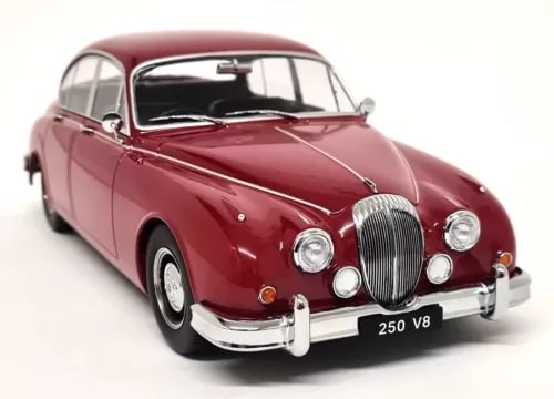 Red diecast model car with black grille, chrome bumper and headlights, front 3/4 view