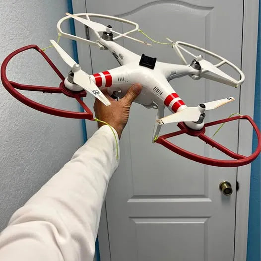 DJI Phantom quadcopter drone with red stripe arms, four propellers, held in a hand