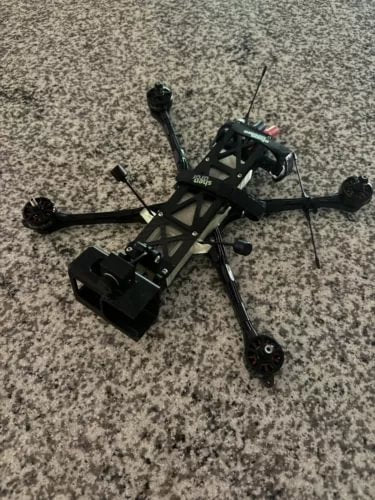 FPV long-range drone with four arms and propellers, black controller module and antennas