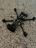 FPV long-range drone with four arms and propellers, black controller module and antennas