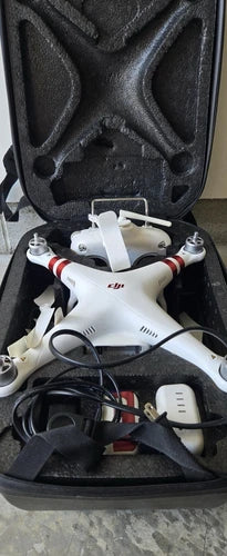 White quadcopter drone with folded arms and propellers in foam case