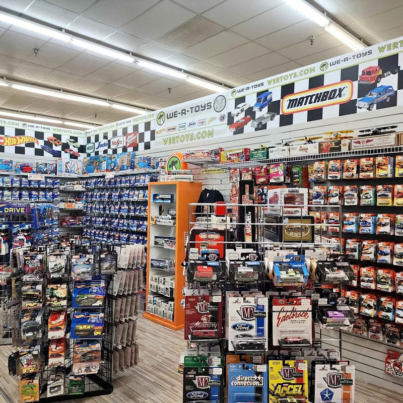 Diecast car display shelves with packaged Hot Wheels and Matchbox cars