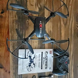 Black quadcopter drone with four propellers, remote controller and packaging