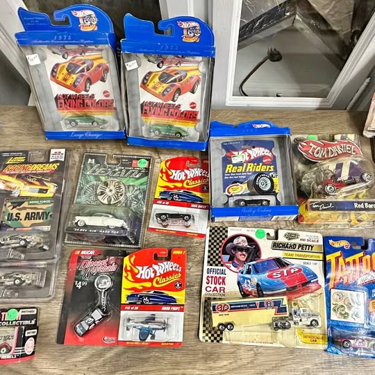 Toy diecast car collection in retail blister packs and boxes, colorful racing designs