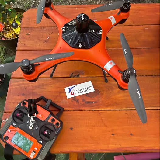 Orange quadcopter fishing drone with four propellers and camera controller, remote included