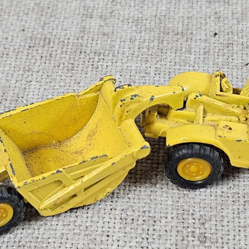 Yellow diecast scraper toy truck with front scoop and black tires