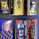 Racing diecast model car in blister box, red and black with white graphics