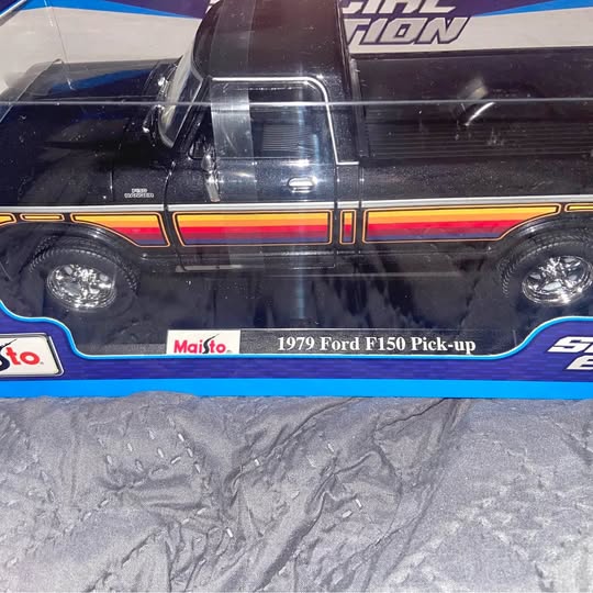Diecast pickup truck model, black with blue and orange stripes, 1979 F150 graphics