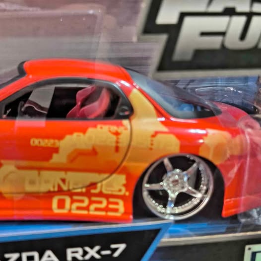 Orange RX-7 diecast sports car model with chrome spoke wheels and side decals