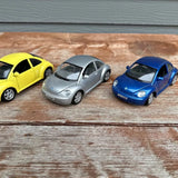 Three New Beetle diecast model cars: yellow, silver, and blue, 1:25 scale