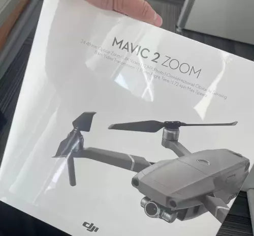 Gray quadcopter drone with gimbal camera and four propellers, on package