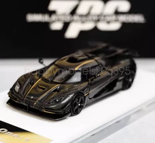 1:64 diecast racing car, black with gold stripes, front three-quarter view