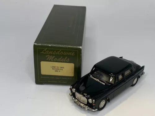 Diecast model car in dark green, front three-quarter view, with display box