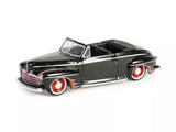 Black 1947 Ford Deluxe convertible diecast car model with chrome trim and red wheel accents