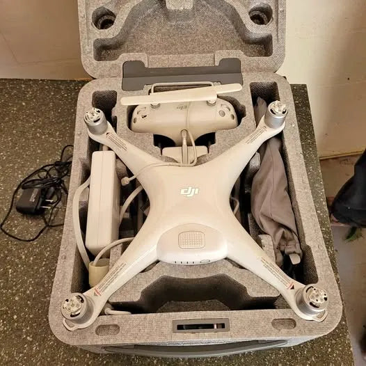 White DJI drone with four propellers in molded carry case