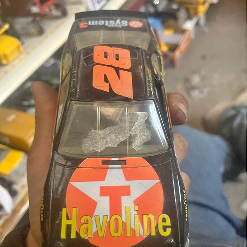 Diecast NASCAR stock car with black body and orange Havoline logo