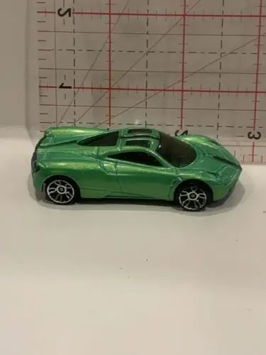 Green diecast toy sports car with black wheels and hood scoop