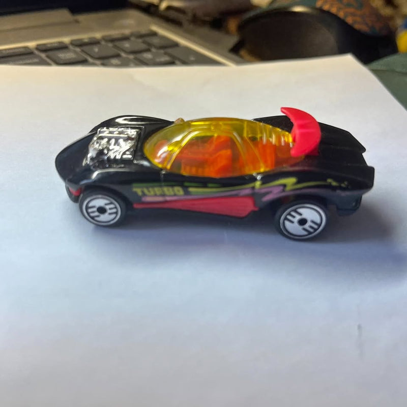 Black diecast toy car with turbo graphic, amber headlights, red spoiler detail