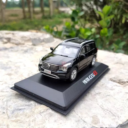 Black diecast SUV model with front grille and headlights, on display base