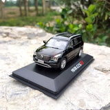 Black diecast SUV model with front grille and headlights, on display base