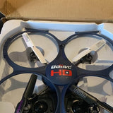 Quadcopter drone with four propellers and front camera, dark body with blue accents