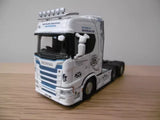 White diecast Scania tractor truck with blue stripe, cab detail, front three-quarter view