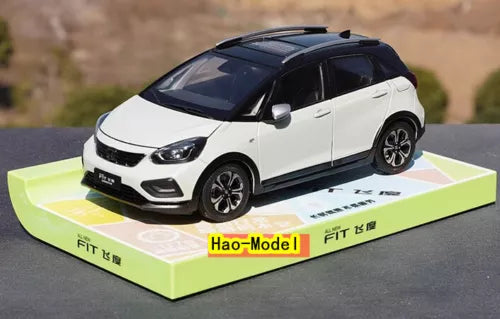 White and blue diecast model car, front three-quarter view on display box