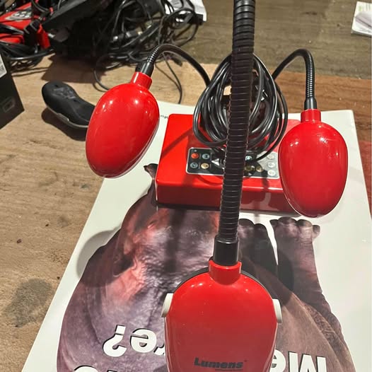 Red document camera with two bulb-style lamps and adjustable stand